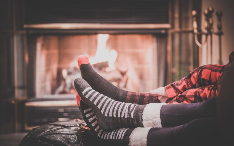 Two parents and baby feet Warming by Fireplace