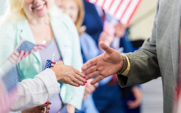 Close up of political candidate shaking hands with a female supporter.