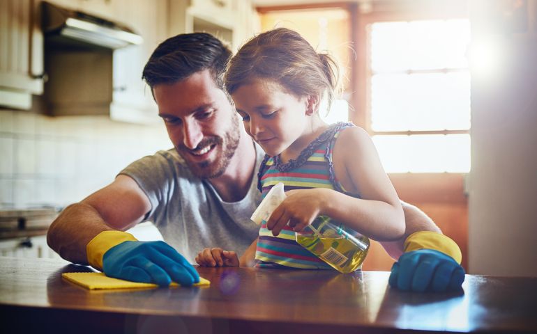 Cropped shot of a father and his little daughter cleaning a kitchen surface together at home