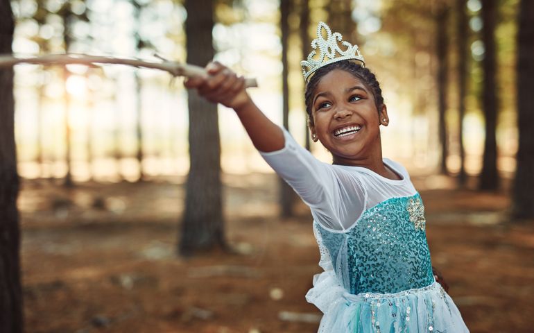 Shot of a little girl dressed up as a princess and playing in the woods