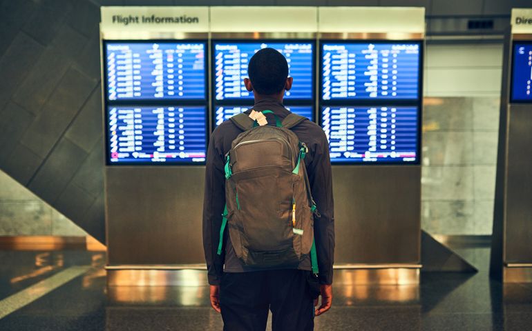 Shot of a man checking the flight times in an airport