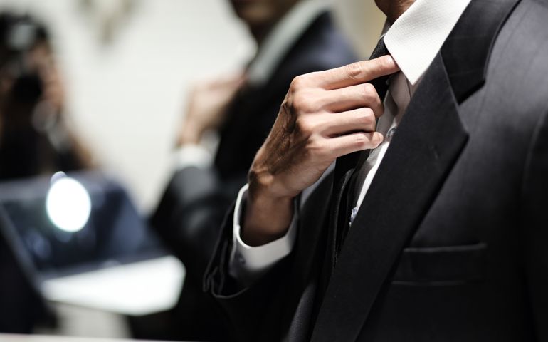 Close up of businessman adjusting necktie