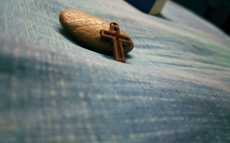 Jesus christian cross leaning against stone with selective focus