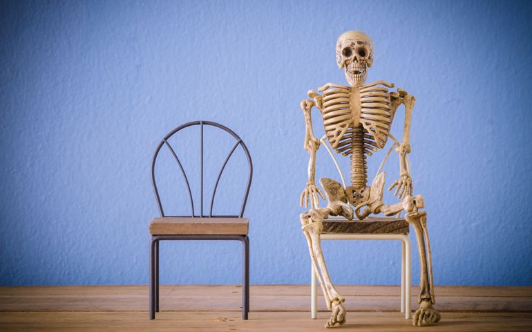 Skeleton sit on chair