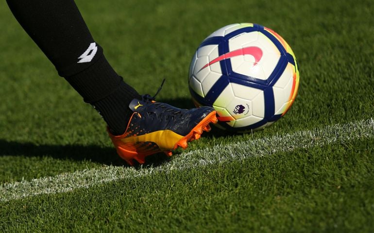 New Nike Ordem 5 ball. Football player in Puma boots shoots the Official Premier League Ball.