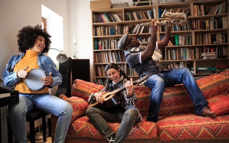 Group of friends playing instruments in studio, having fun.