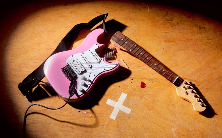 electric guitar left smashed on stage at the end of a rock and roll performance