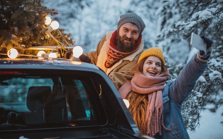 Couple arrived home with Christmas tree, it is snowy weather and everything need to be perfect for Christmas. They take selfies