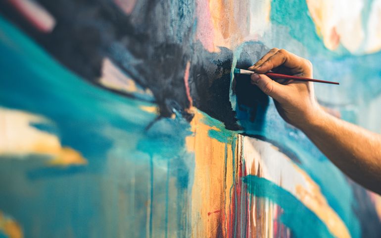 Hands of Young painter working on his art inside his studio.