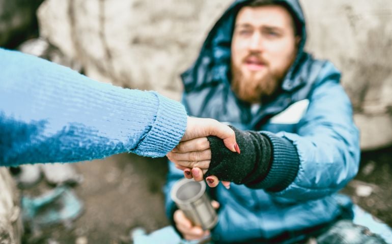 Homeless Male On The Street Getting Help From Female