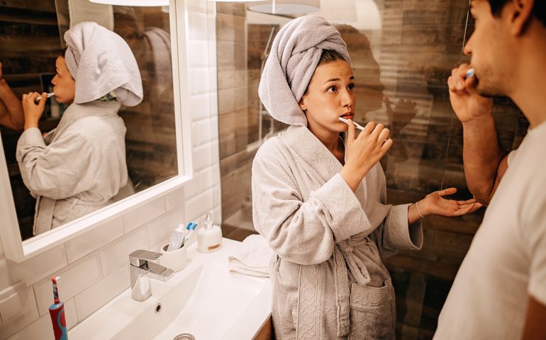 Couple brushing teeth in bathroom