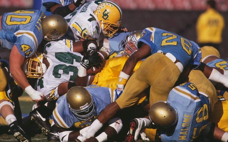 Dwayne Jones #34, Running Back for the University of Oregon Ducks is tackled by the University of California, Los Angeles UCLA Bruins defensive line during their NCAA Pac-10 Conference college football game on 16th November 1991 at the Rose Bowl Stadium, Pasadena, United States. The UCLA Bruins won the game 16 - 7.