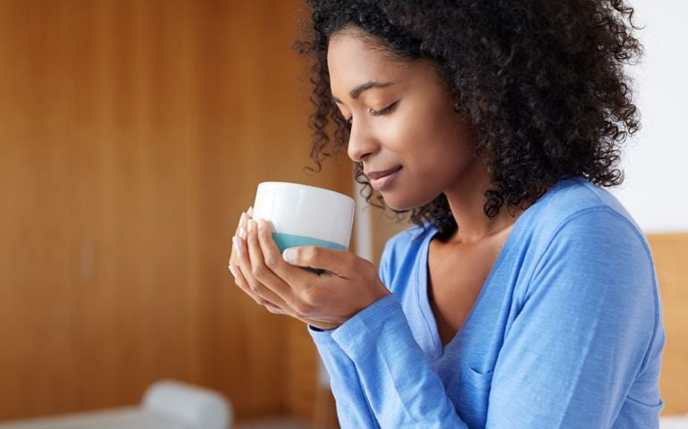 Shot of a young woman having a cup of coffee at home
