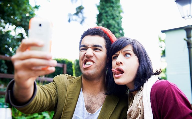 man and woman making funny faces for selfie