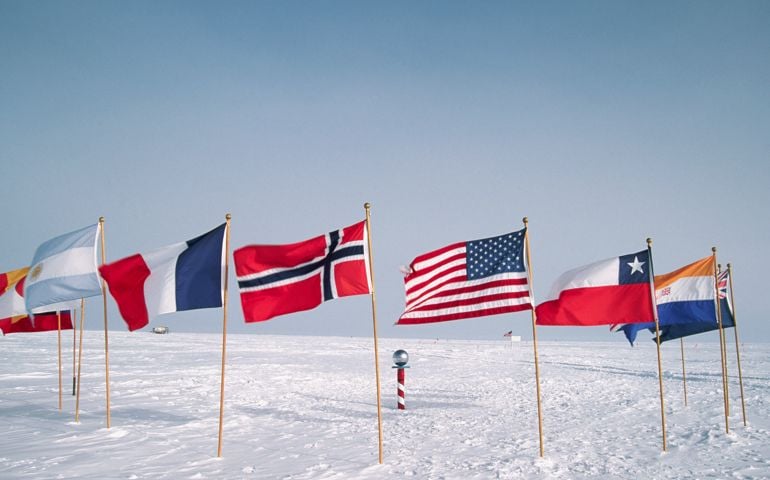 Flags mark the ceremonial South Pole, while the true South Pole is visible in the distance.