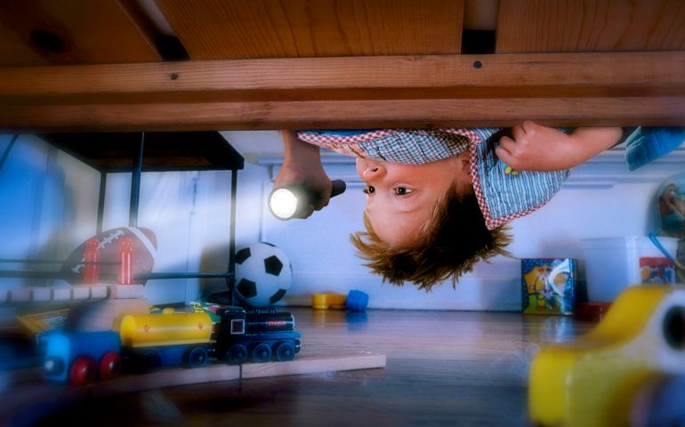 Boy Checking Under Bed with Flashlight