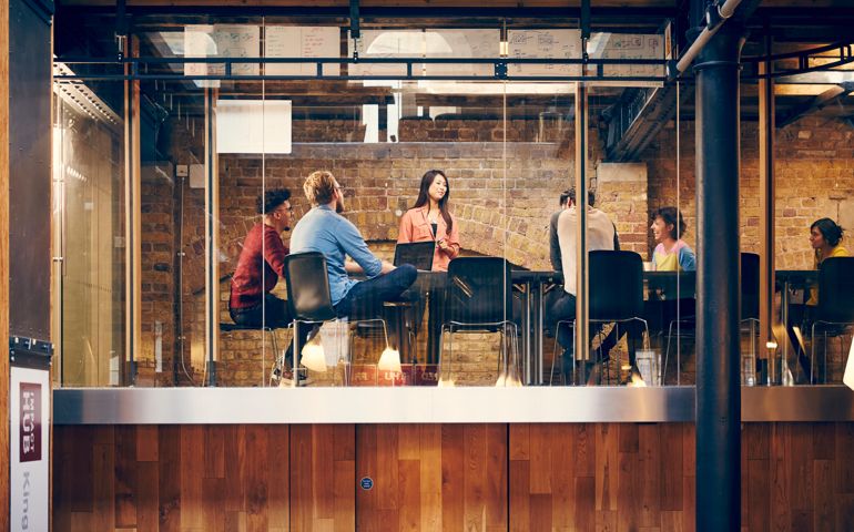 A team of creative professionals hold a meeting in a modern office space.