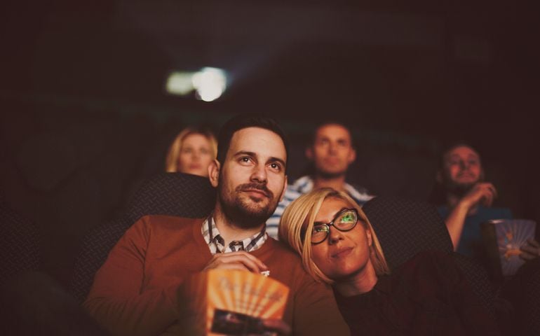 Young couple at the cinema watching movie