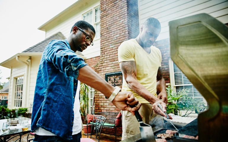 Friends barbecuing during backyard party