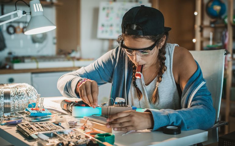 Teenage girl working on some engineering project at home.