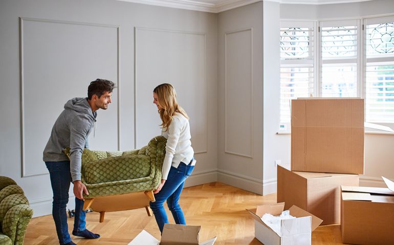 Shot of a young couple moving a couch into their new home