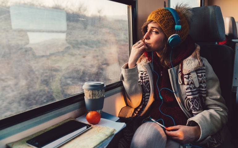 Thoughtful woman in the train looking through the window