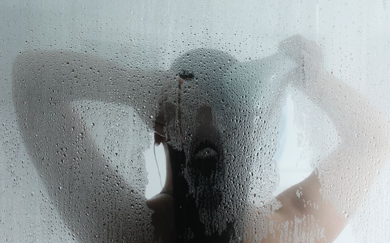 A female taking a hot steam shower.