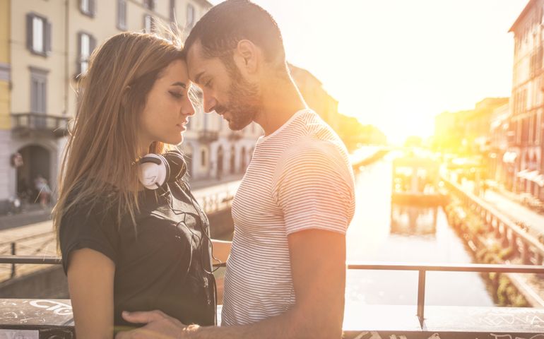 Young couple passionated moment. Couple kissing on a bridge