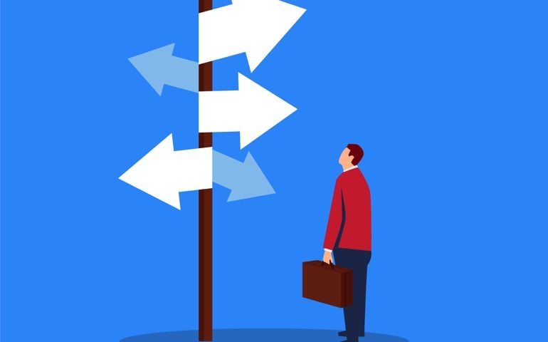 Businessman looking at complicated street sign