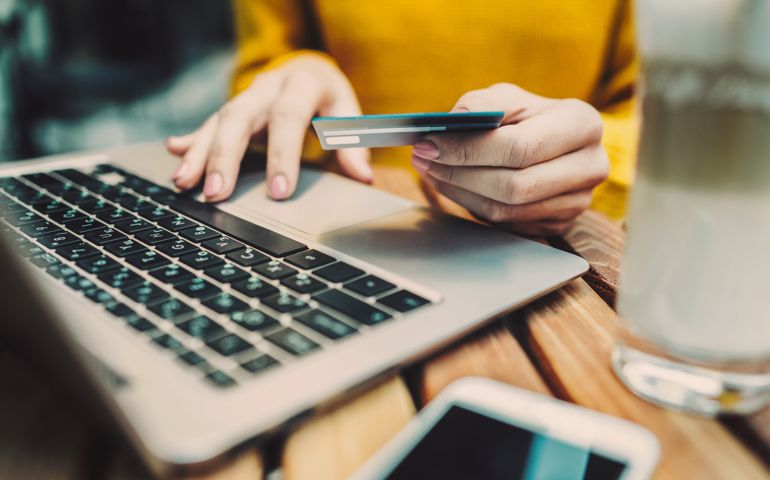 Woman's hands holding credit card and typing on keyboard on laptop
