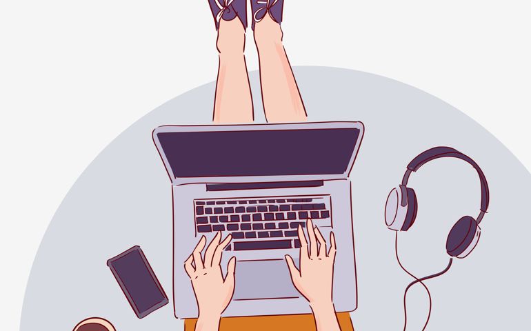Young woman sitting on floor and working on laptop computer