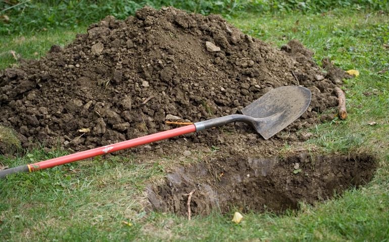 Pile of dirt, shovel and a hole