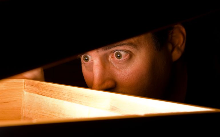 A man is surprised by what he finds in a box.