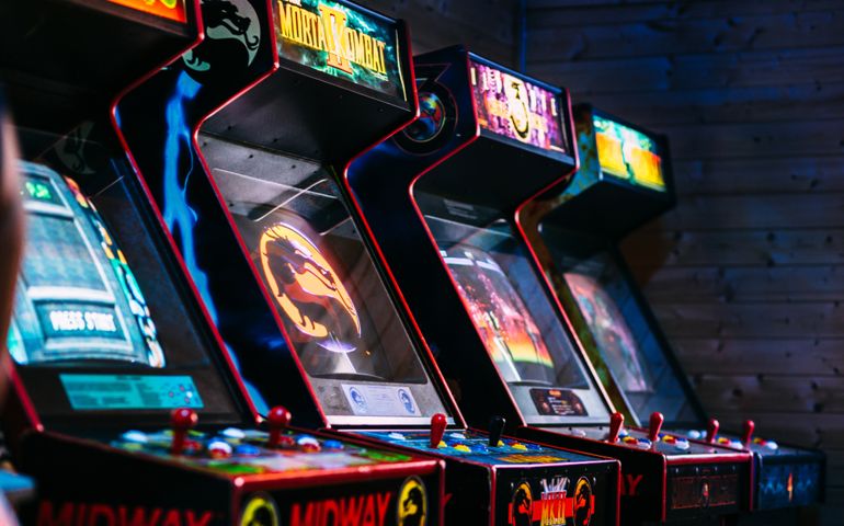 Iconic Vintage Arcade Games Including fighting game Mortal Combat stored in a dark gamer room