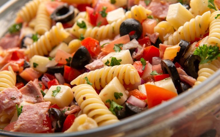 fresh italian pasta salad with salami, black olvies, tomato, mozzarella