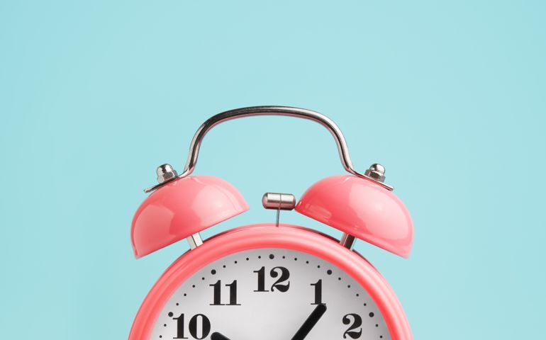 Red alarm clock on blue background