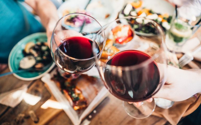 Close up of a friends toasting with red wine at restaurant