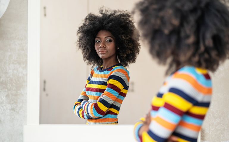 Afro Woman looking at her reflection in the mirror
