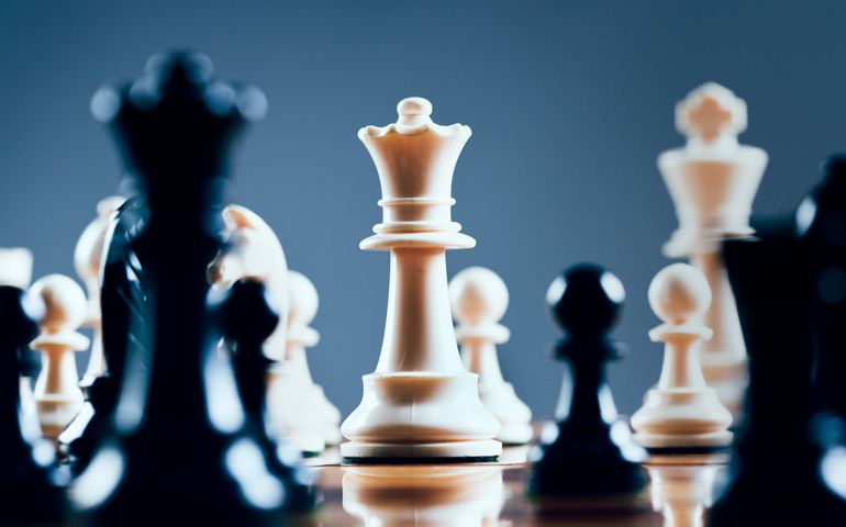 Close up of chessmen on chessboard, with the focus on the centrally placed white queen. Shot with Canon EOS 1Ds Mark III.