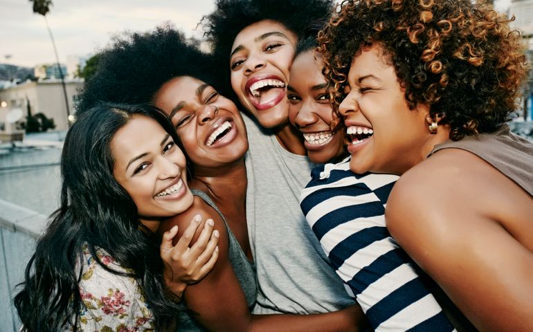 Women laughing together on urban rooftop
