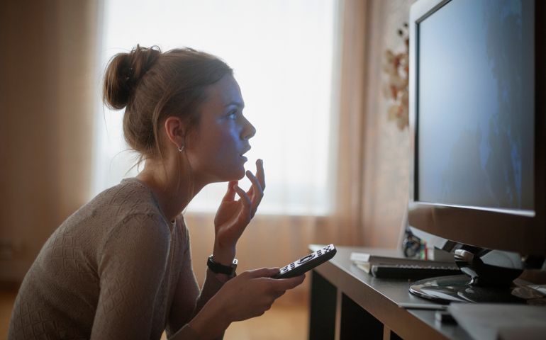 sitting on fllor close to flat screen
