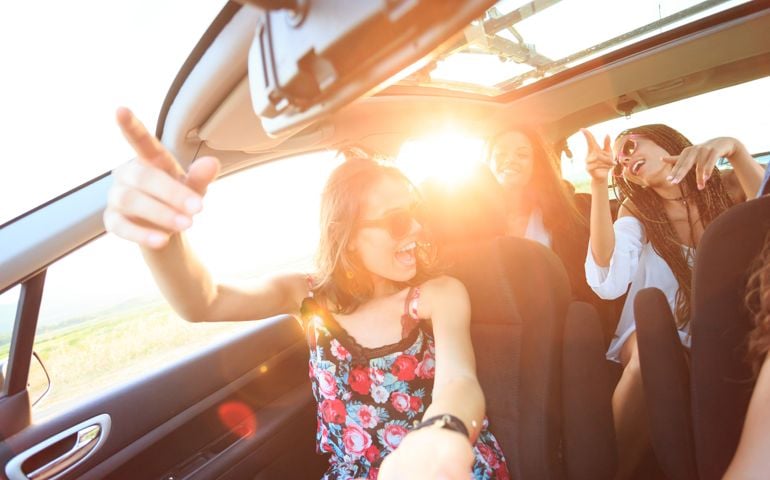 Group of young people traveling with car and having fun, singing.