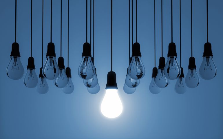 hanging light bulbs, one is switched on,