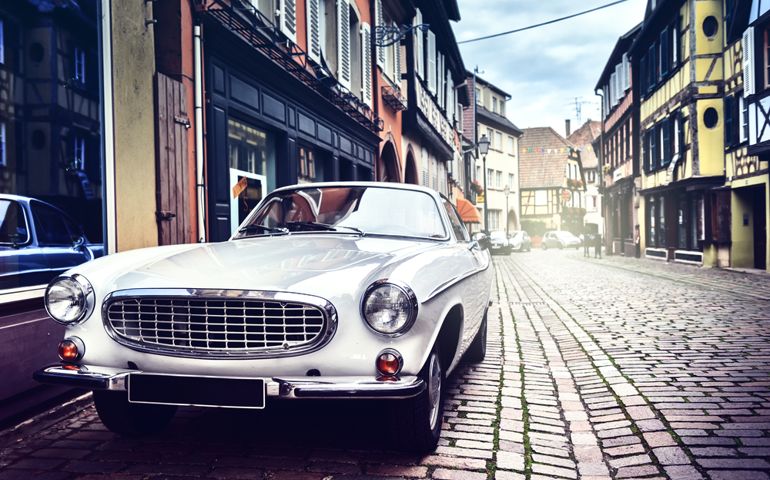 Retro car parked in old European city street