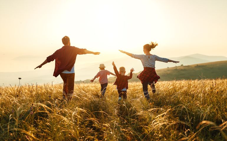 Happy family: mother, father, children son and daughter on nature on sunset