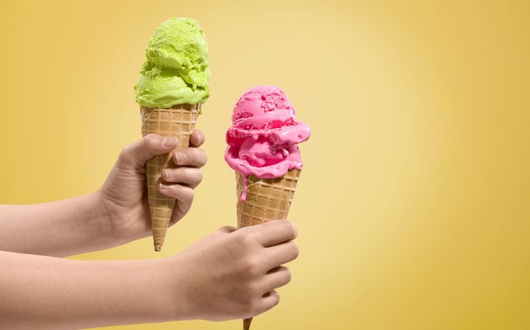 Hands holding ice-creams of different flavours.
