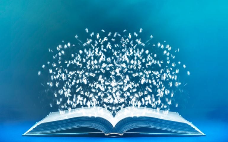 Bits of light floating above opened book