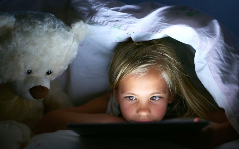 Shot of a little girl using a digital tablet under a blanket fort at home