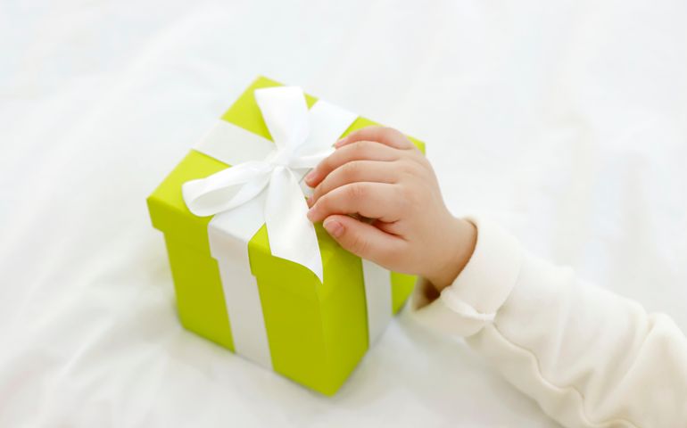 Baby hand holding gift box