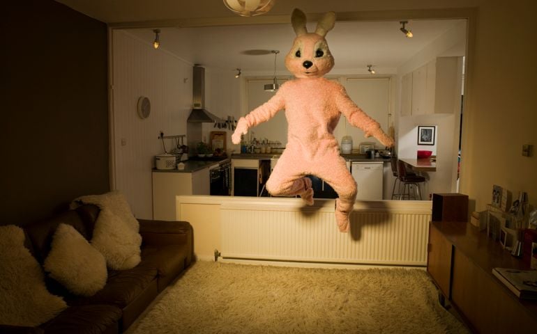 Person in rabbit costume jumping in room